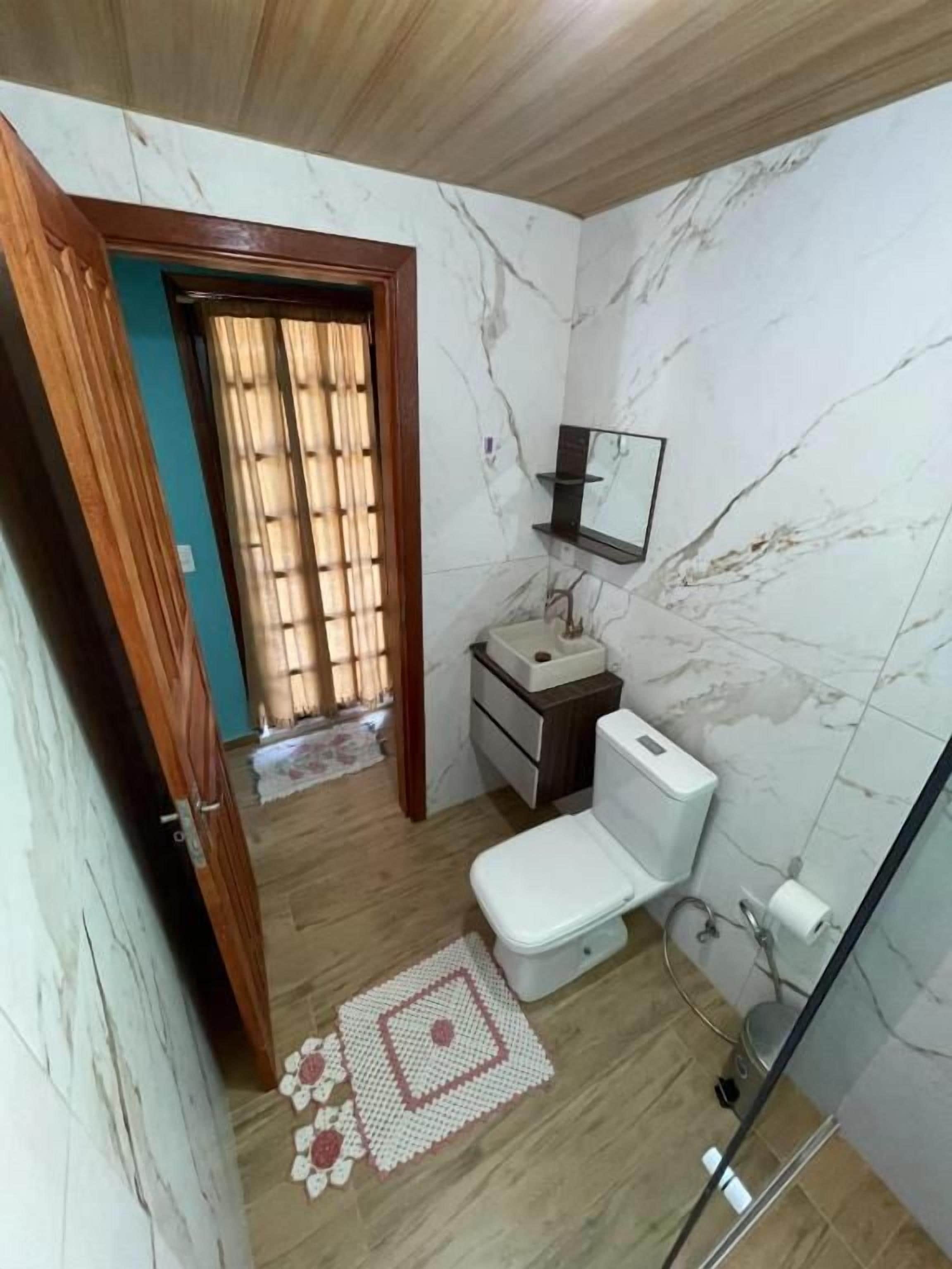 Un baño con inodoro, lavamanos y espejo.