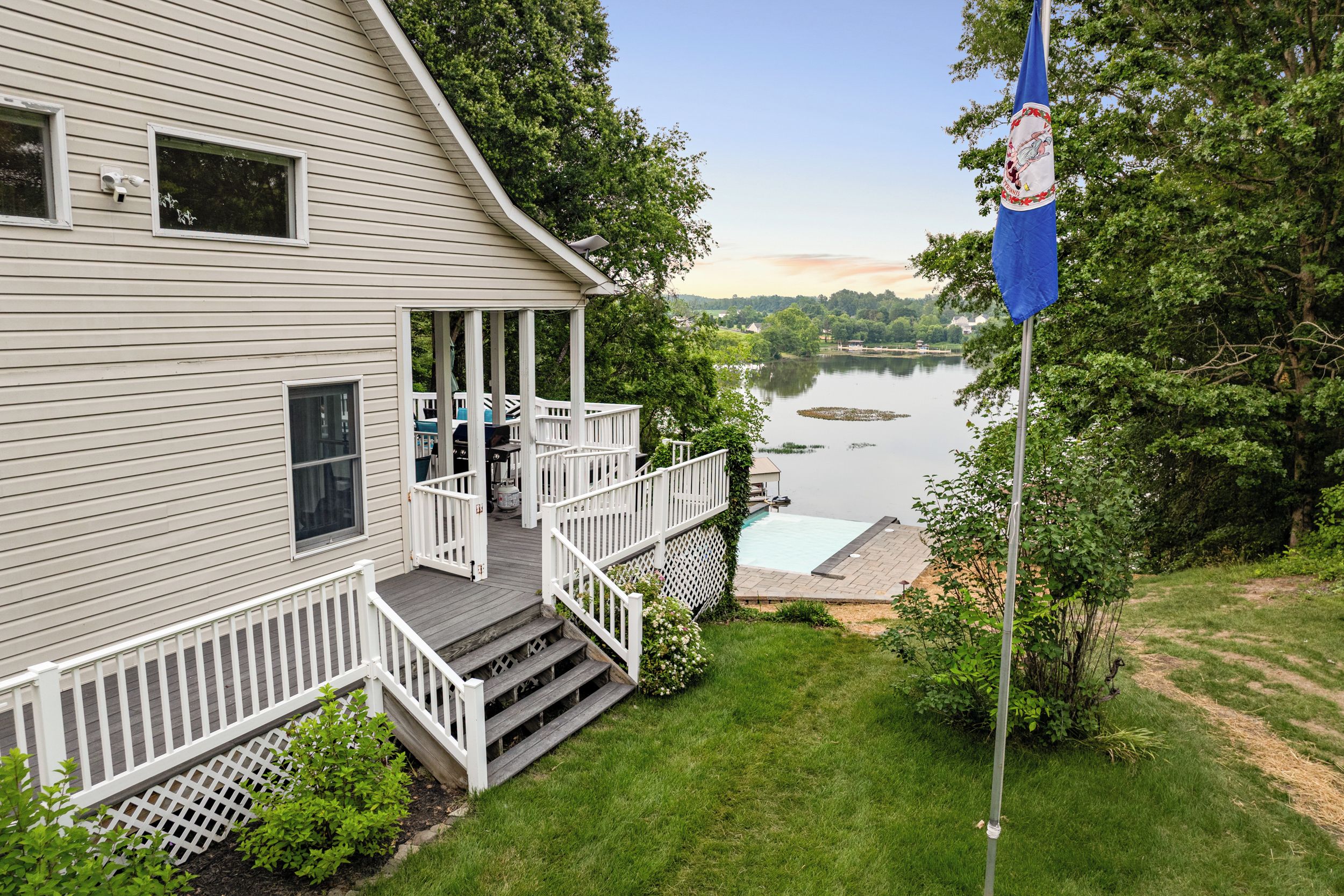 Exterior - Deck stairs drop from the house toward the pool terrace and the water below.