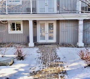 A residential building with a front entrance, a number '709' on the door, and a brick pathway leading to the door. - K's Condominium - Minutes to Ski, Trails, Shops, Beach (Collingwood)