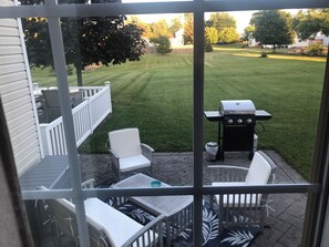 A patio with outdoor furniture, a grill, and a view of a well-maintained lawn. - 3-bedroom townhome in soothing Sackets Harbor with AC (Sackets Harbor)