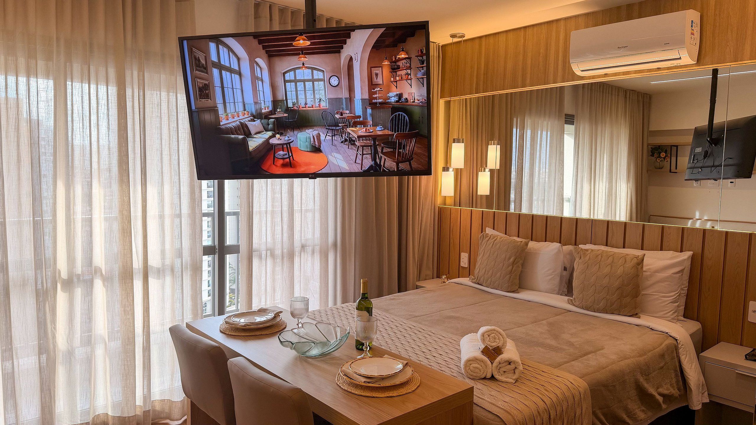 Una habitación de hotel con cama, mesita de noche, televisor y cortinas.