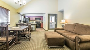 A compact living space with a dining area, kitchenette, and a sofa.