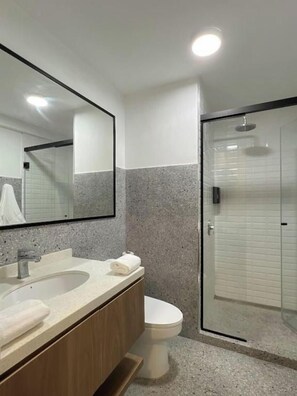 A bathroom with a large mirror, a sink, a toilet, and a shower enclosure. - Miraflores City Diagonal Apartments By Geko (Miraflores)