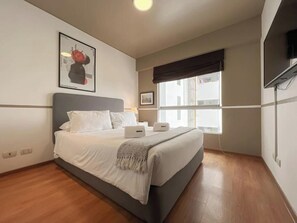 A bedroom with a bed, a window, a wall-mounted TV, and a framed picture. - Barranco Sailor Apartment By Geko (Barranco)