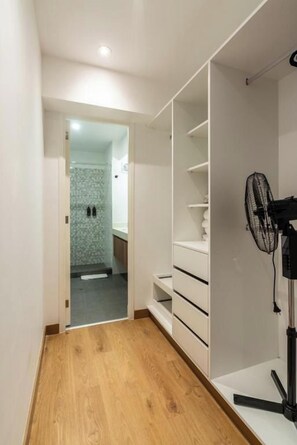 A hallway with a wooden floor leading to a bathroom with a tiled shower area. - José Gonzales 626 Apartments Near Kennedy Park By Geko (Miraflores)