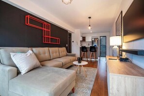 A modern living room with a sofa, a coffee table, and a TV stand. - Suárez Signature Apartment By Geko (San Isidro)