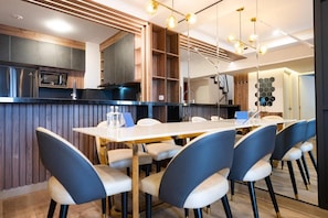 Eine moderne Küche mit integriertem Mikrowellenherd, einer Holztischplatte und einem Essbereich mit weißem Tisch und blauen Stühlen.