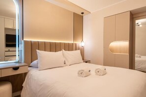 Ein Hotelzimmer mit Bett, Nachttisch, Spiegel und Kleiderschrank.