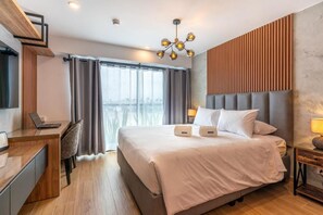 A modern hotel room with a large bed, a desk, and a view of the city. - Ejército City Lofts & Apartments By Geko (Miraflores)