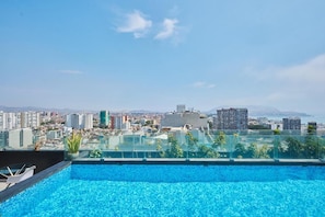 A rooftop pool with a cityscape view, including high-rise buildings and mountains in the distance. - Barranco Bright Apartment With Balcony (Barranco)