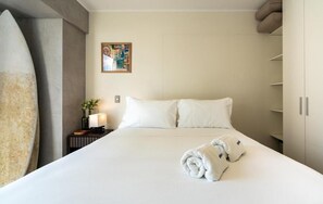 A hotel room with a large bed, a nightstand with a lamp, a painting on the wall, and a wardrobe. - Executive San Isidro Residence By Geko (San Isidro)
