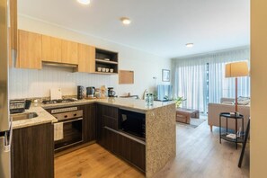 Una cocina moderna con gabinetes de madera oscura, encimera de granito y horno empotrado.