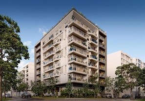 Un edificio residencial de varios pisos con balcones y cielo despejado.