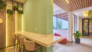 Un intérieur moderne avec un bar, des sièges et une plante en pot.