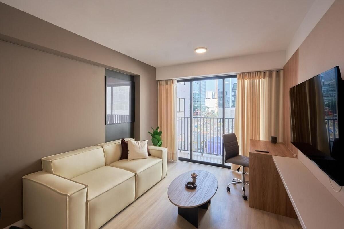A modern living room with a sofa, coffee table, and a TV.