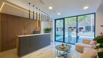 Un área de recepción moderna con mostrador, sofá y una mesa de centro.