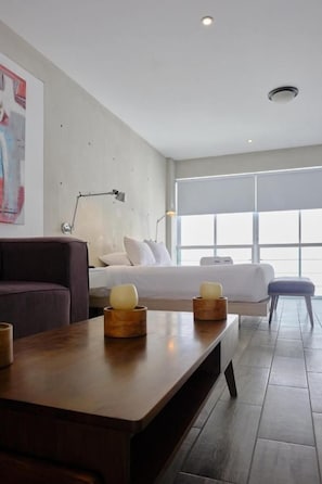 Ein modernes Hotelzimmer mit einem Bett, einem Schreibtisch, einem Stuhl und einem großen Fenster.