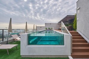 A rooftop infinity pool with a glass edge, surrounded by lounge chairs and a staircase leading to an upper level. - Urban 28 De Julio 551 Stay By Geko (Miraflores)