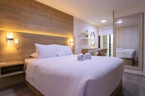 A modern hotel room with a large bed, bedside tables, a mirror, and a wardrobe. - Urban 28 De Julio 551 Stay By Geko (Miraflores)