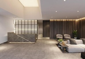 Ein moderner Empfangsbereich mit einer Marmor-Rezeption, einer Sitzecke mit Sofas und einer Wand als Holzdekor.