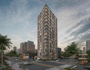 A high-rise building with a grid-like facade, surrounded by palm trees and a crosswalk. - Javier Prado 595 Residences By Geko (San Isidro)