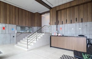 A modern lobby with a reception desk, a staircase, and a seating area. - Work And Living Suites In Miraflores By Geko (Miraflores)