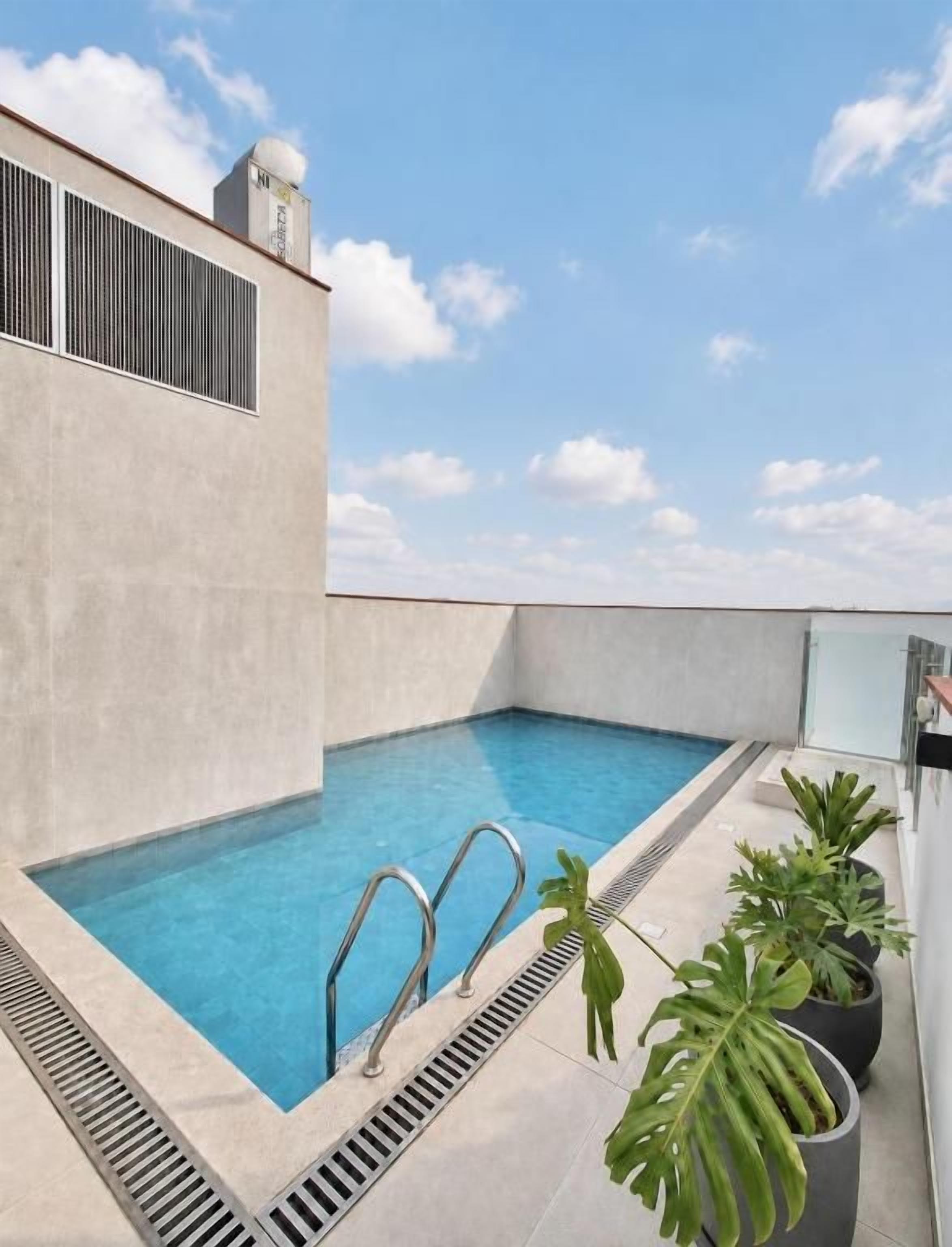 Una piscina en la azotea con cielo despejado y algunas nubes.