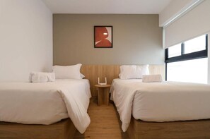 A hotel room with two beds, a small table, and a wall-mounted artwork. - Designer 2Br Perfect View Near Costa Verde By Geko (Miraflores)