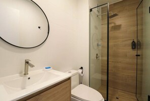 A modern bathroom with a glass-enclosed shower, a white sink, and a toilet. - Designer 2Br Perfect View Near Costa Verde By Geko (Miraflores)
