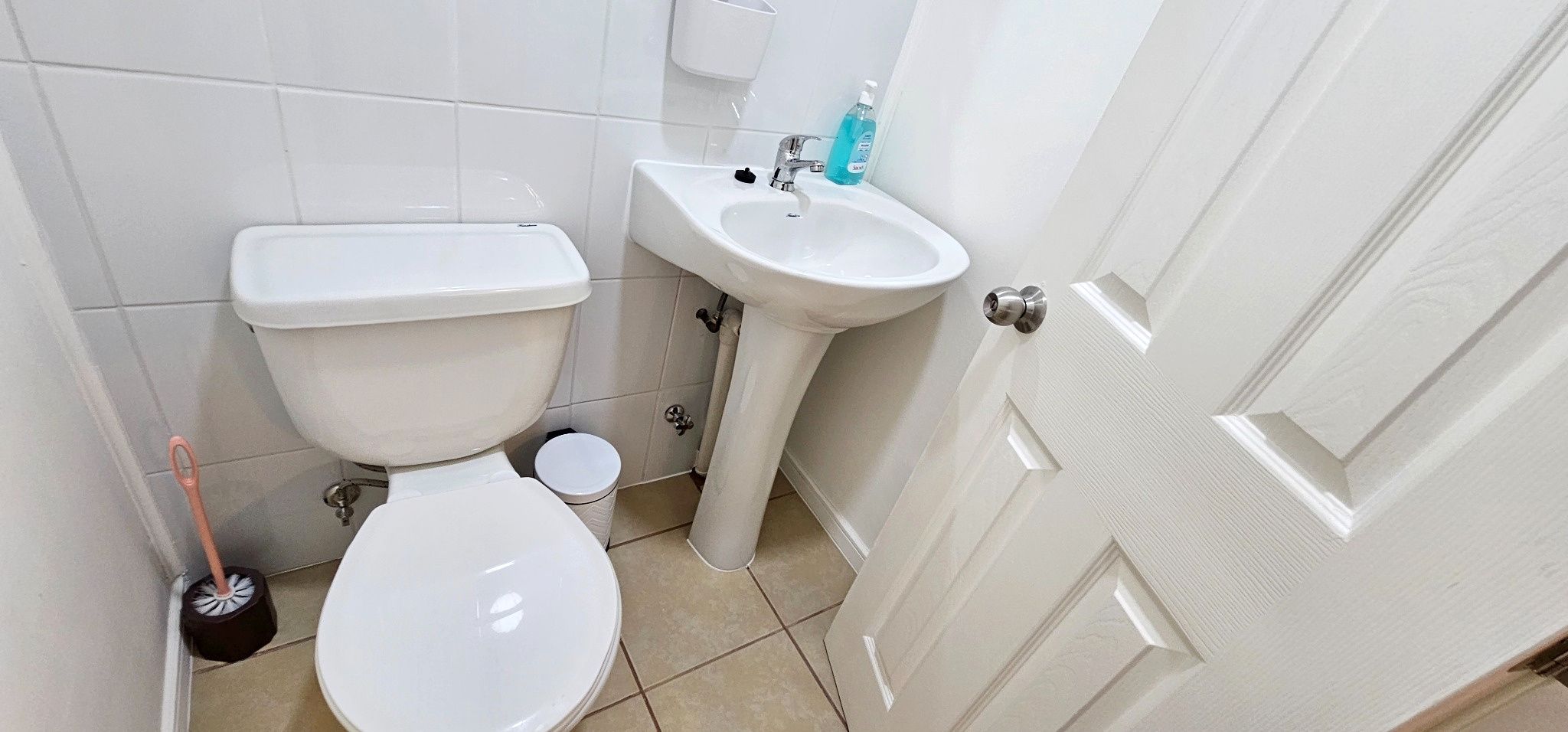 Une salle de bain avec des toilettes, un lavabo et une porte.