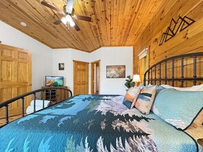 A bedroom with a bed, wooden ceiling, a TV, and a painting on the wall. - Dreaming Tree Cabin; bike in/out, resort amenities (Mars Hill)
