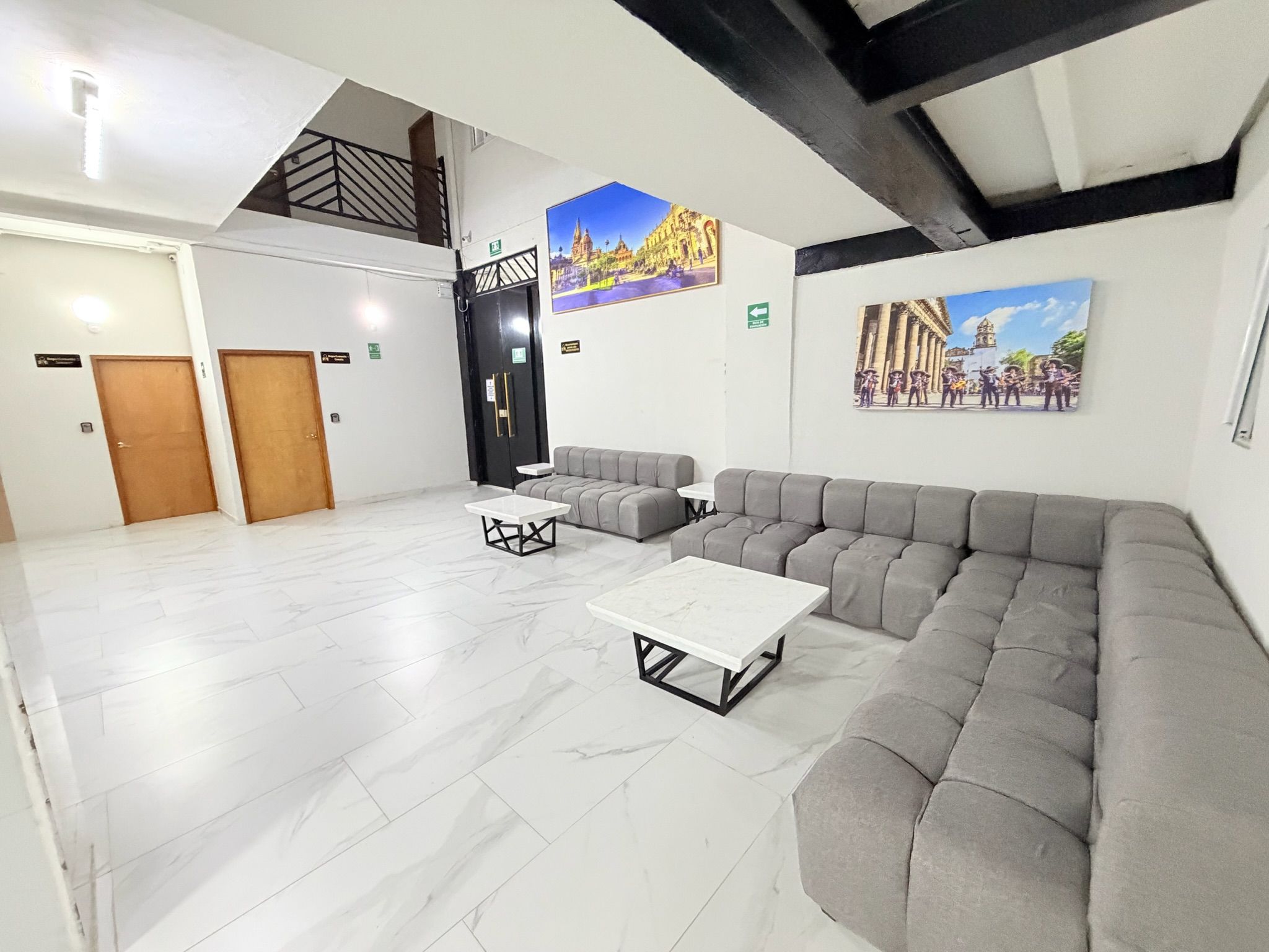 Un amplio vestíbulo con un sofá modular, una mesa de centro y una escalera.