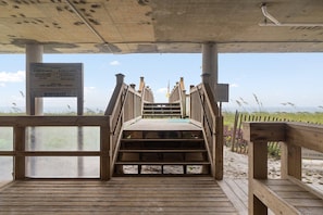 A wooden boardwalk leading to a beach area with a sign indicating no tents or canopies allowed. - Windemere 1407 (Pensacola)