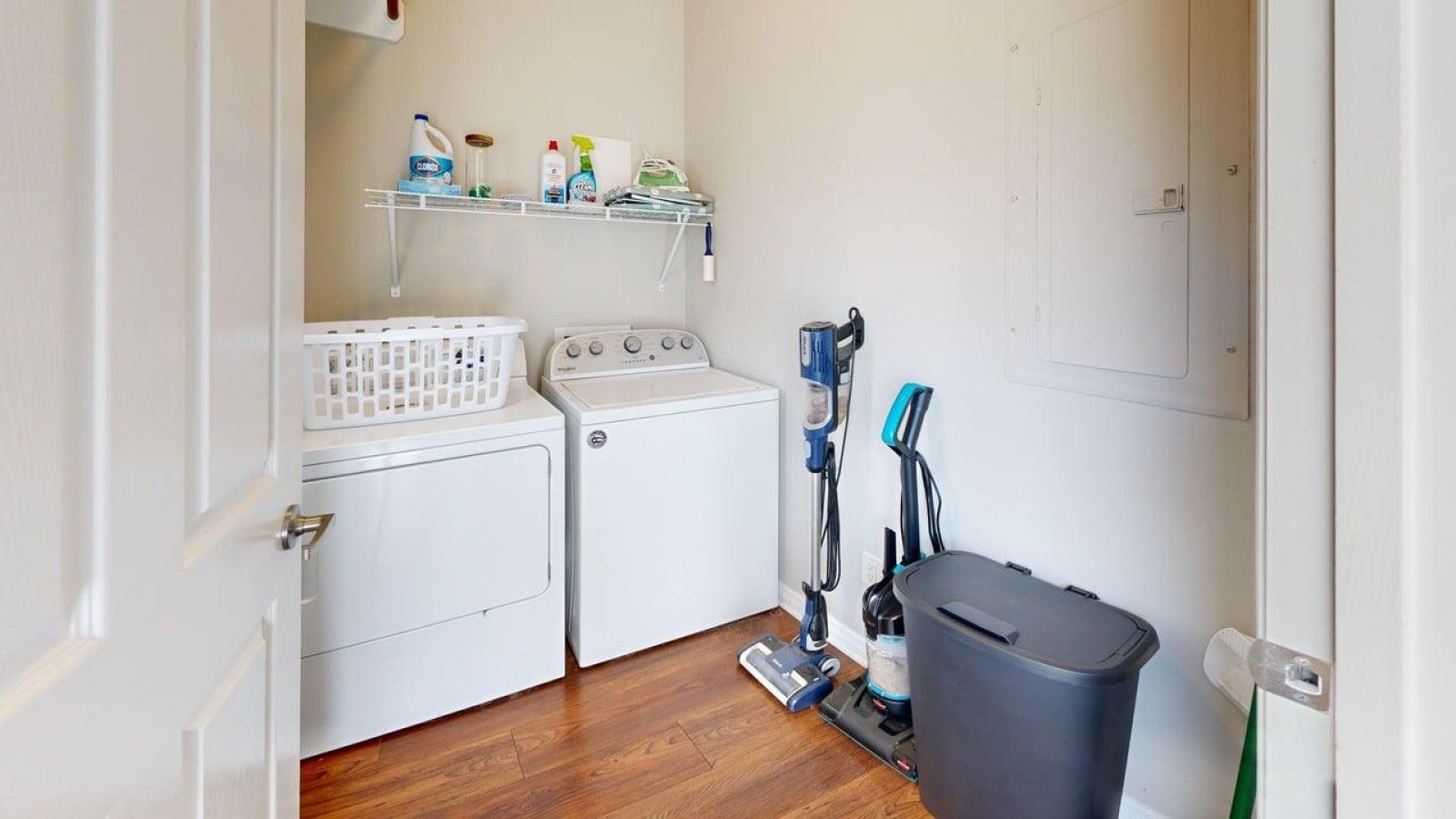 A laundry area with a washing machine, dryer, and a vacuum cleaner.