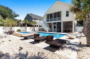 A poolside area with lounge chairs and a staircase leading to a building. - Private Saltwater Pool within Walking Distance to the Beach Oak Island NC (Oak Island)