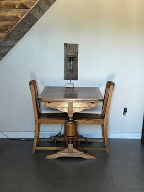 A dining table with four chairs, a wooden floor, and a sloped ceiling. - Country-chic private guesthouse with laundry. (Queen Creek)