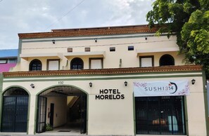 A building with a sign for 'HOTEL MORELOS' and a banner for 'SUSHI314.'