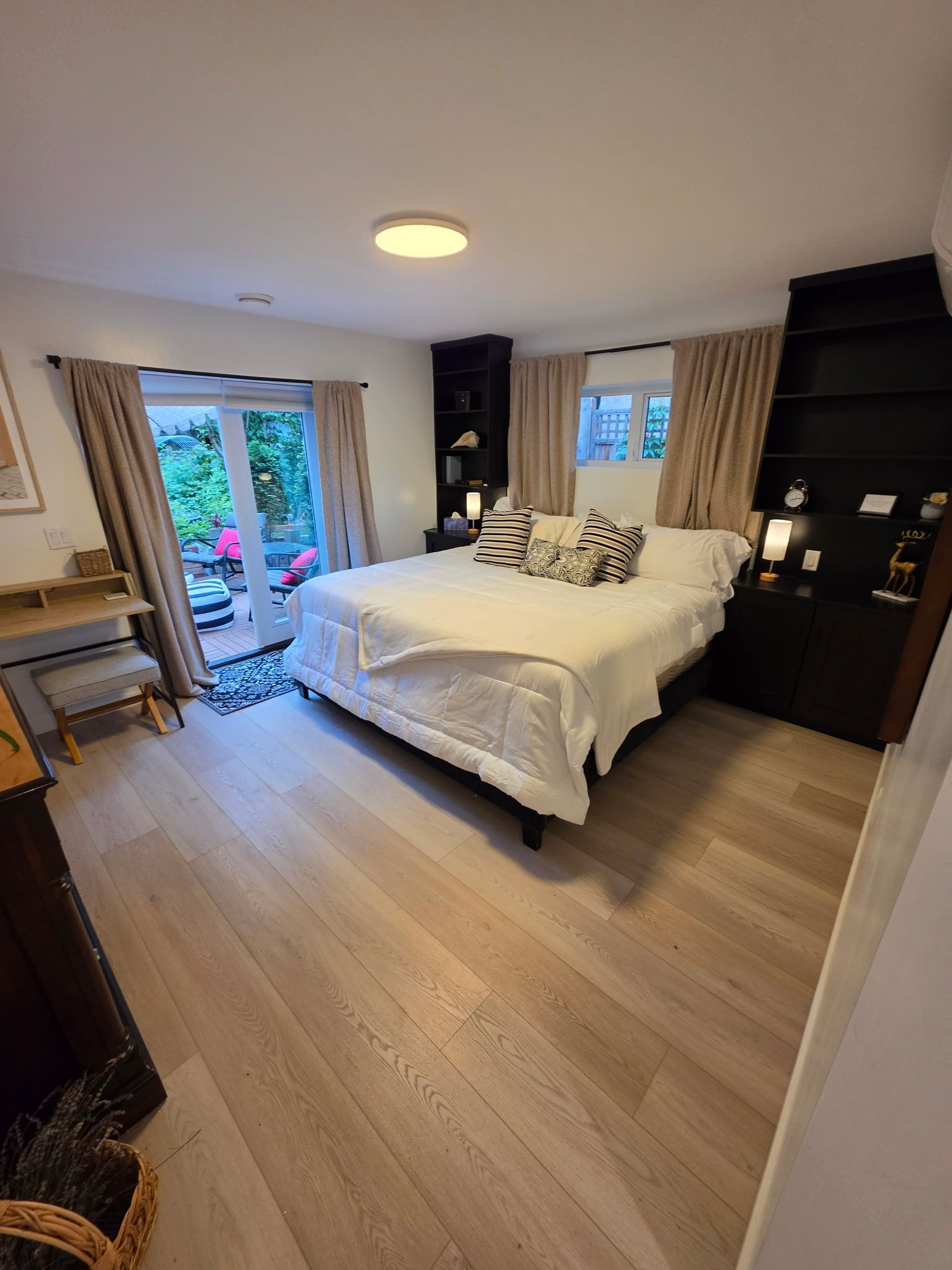 Een slaapkamer met een bed, nachtkastjes, een bureau en een kledingkast.