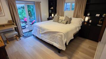 Een slaapkamer met een bed, nachtkastjes, een bureau en een kledingkast.