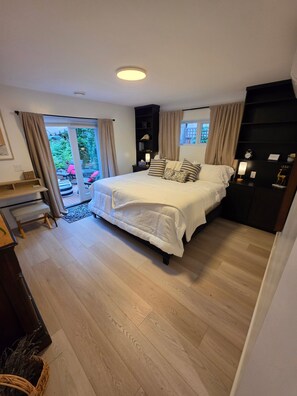 Ein Schlafzimmer mit Bett, Nachttischen, einem Schreibtisch und einem Kleiderschrank.