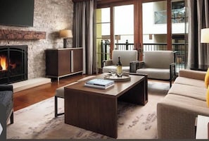Ein modernes Wohnzimmer mit Kamin, einer Couch, einem Couchtisch und einem Bücherregal.