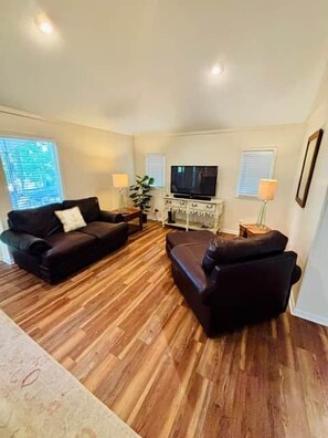 A living room with a sofa, a coffee table, a TV, and a lamp. - Yellow Buoy at Pickwick Lake (Hardin County)