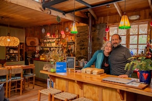 Un interior rústico con vigas de madera, una zona de bar y un espacio de estar con taburetes.