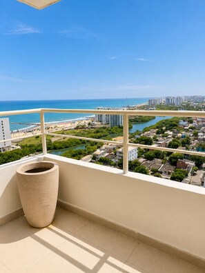 Ein Balkon mit Blick auf einen Strand, einen Fluss und eine Skyline.