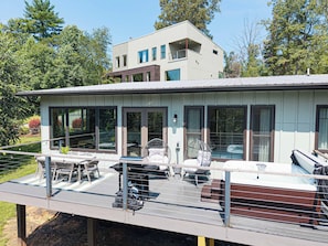 A modern two-story house with a deck, large windows, and outdoor furniture. - Pickleball, Game Room, Firepit, Putt putt, Hot Tub (Leicester)
