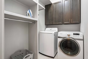 A laundry room with a washing machine, dryer, and cabinets. - Pickleball, Game Room, Firepit, Putt putt, Hot Tub (Leicester)