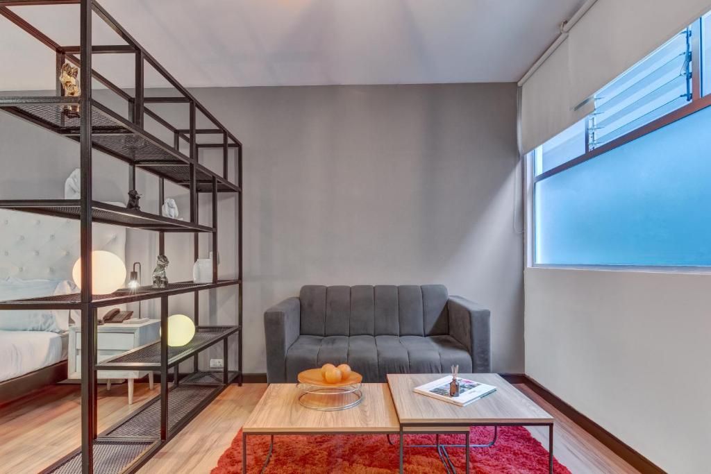 Un salon moderne avec un canapé gris, une table basse et une bibliothèque.