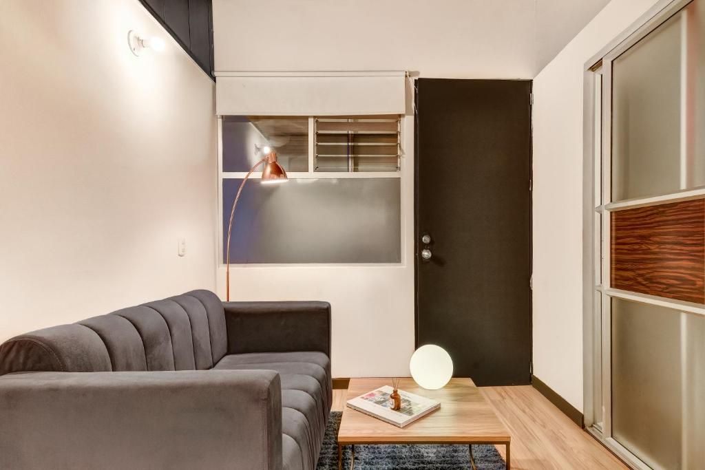 A modern living room with a sofa, a coffee table, and a door with a frosted glass panel.