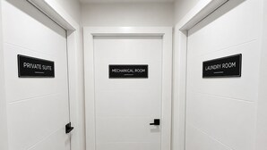 A hallway with three doors labeled 'PRIVATE SUITE,' 'MECHANICAL ROOM,' and 'LAUNDRY ROOM.' - Brand-New Legal Suite | East Regina (Regina)