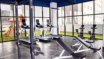 A gym with treadmills, weight benches, and exercise equipment.